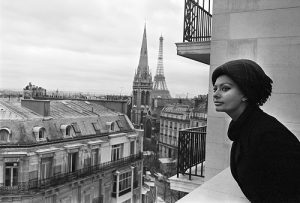 France, Paris, 17 novembre 1964, l'actrice italienne Sophia LOREN s'installe dans la capitale française avec son époux, le producteur italien Carlo Ponti. Ils investissent plusieurs étages d'un immeuble situé avenue Georges V. Ici l'actrice se penche par-dessus son balcon pour admirer la vue. A l'arrière-plan, on aperçoit la Tour Eiffel.