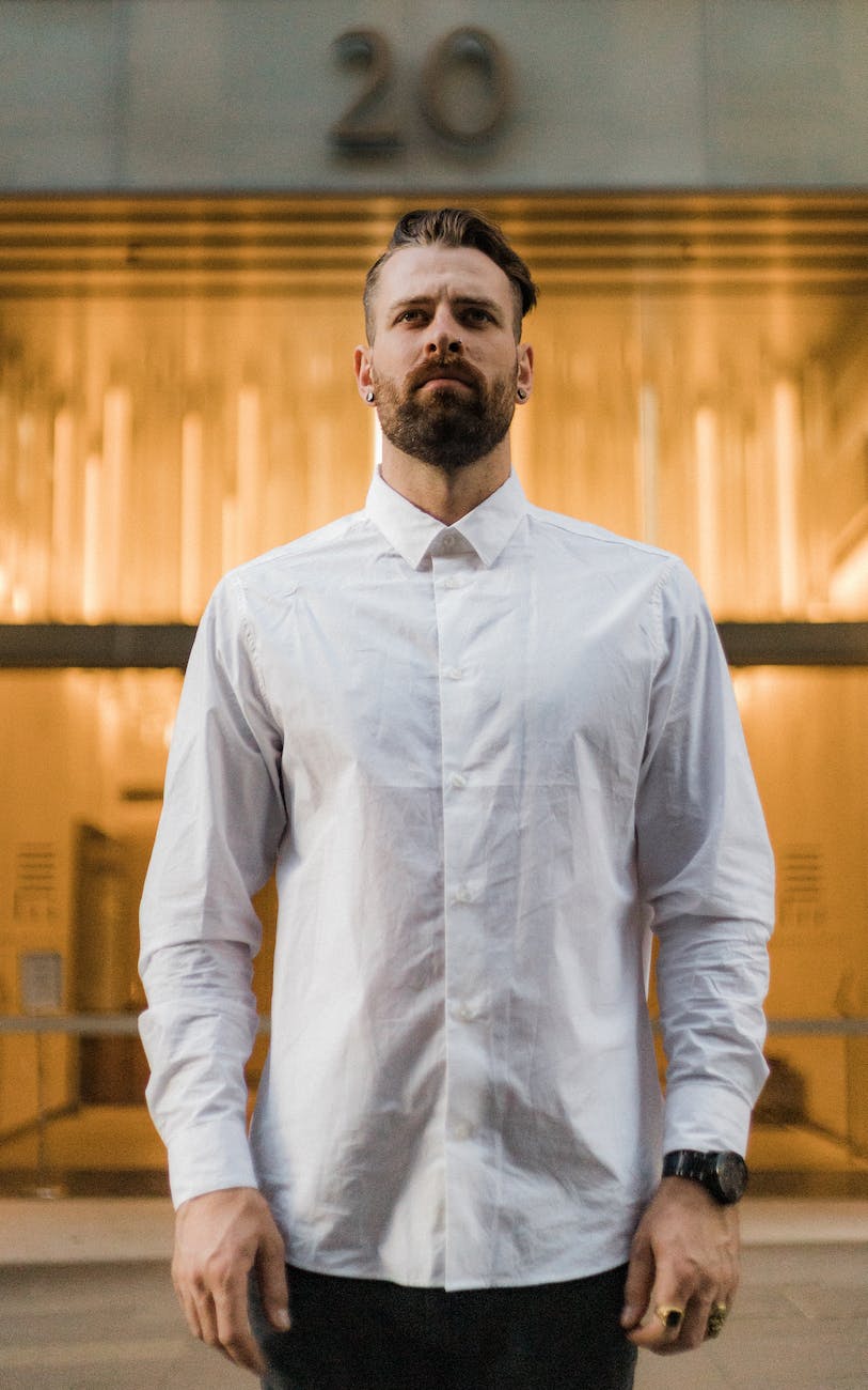 selective focus photo of man in white dress shirt posing