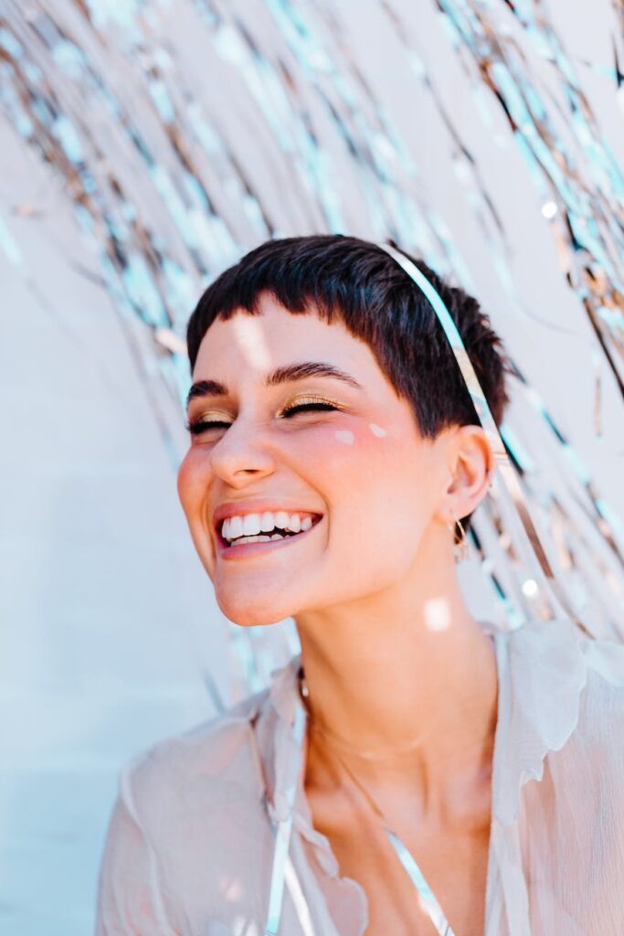 cheerful woman standing near silver tinsel