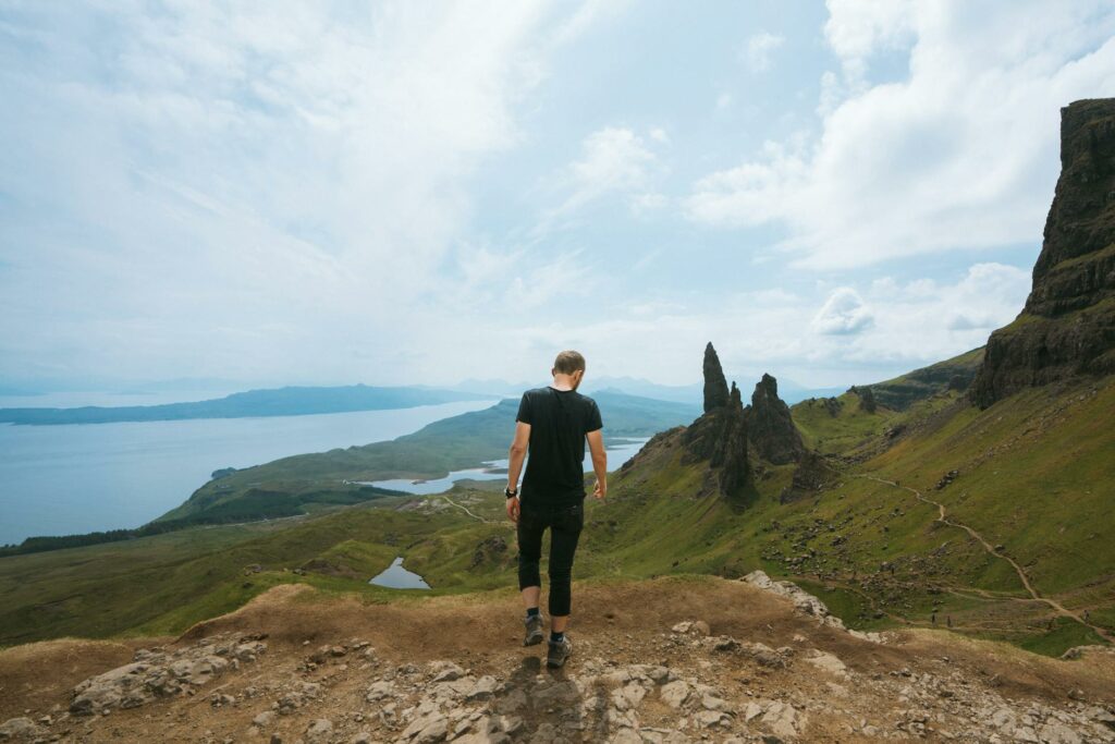 man wearing black t shirt standing on cliff